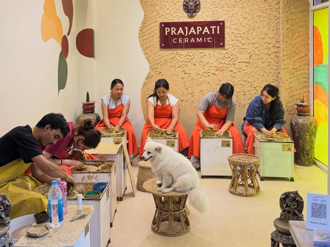 Guests making pottery with the studio dog nearby